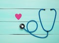 Stethoscope and heart on a blue wooden table. Cardiology equipment for diagnosing cardiovascular diseases. Top view. Flat lay.