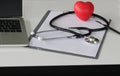stethoscope, heart, computer and chart on table working of doctor, mediscine concept, selective focus