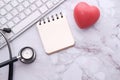 Stethoscope, heart, keyboard and notepad on tile background Royalty Free Stock Photo