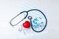 Stethoscope, heart, pills and cardiograms on wooden background, top view. Royalty Free Stock Photo