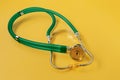 A stethoscope is isolated on a yellow background