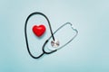 Stethoscope and Red Heart Shape on a Pale Blue Background Symbolizing Healthcare