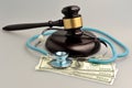 Stethoscope With Judge Gavel, Money On Gray Background