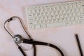 Stethoscope and keyboard computer on modern medical information technology diagnostics flat lay top view Royalty Free Stock Photo