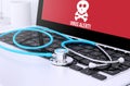 stethoscope on laptop keyboard with screen showing virus alert Royalty Free Stock Photo