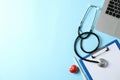 Stethoscope, laptop, tablet, pen and heart on blue background Royalty Free Stock Photo