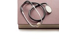 Stethoscope on a large closed book on a white background