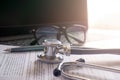 stethoscope lay on computer with pen and glasses, documents. Royalty Free Stock Photo