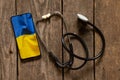 The stethoscope lies next to the phone and a photo of the national flag of Ukraine is yellow and blue. Doctors during the war,