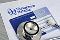 Stethoscope lying on a European health insurance card and a health insurance sheet