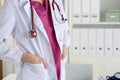 Stethoscope lying on female therapeutist doctor chest in office