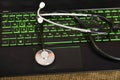 Stethoscope is lying on a green keyboard on a laptop, office equipment repair concept