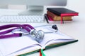 Stethoscope lying on a table on an open book Royalty Free Stock Photo