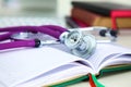 Stethoscope lying on a table on an open book Royalty Free Stock Photo