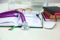 Stethoscope lying on a table an open book Royalty Free Stock Photo