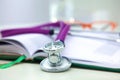 Stethoscope lying on a table an open book Royalty Free Stock Photo