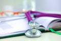 Stethoscope lying on a table an open book Royalty Free Stock Photo
