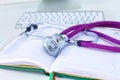 Stethoscope lying on a table an open book Royalty Free Stock Photo