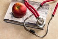 Stethoscope, medical book and red apple Royalty Free Stock Photo