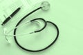 Stethoscope and medical documents on doctor table on lightly green background, closeup, view directly above. Medical examination,