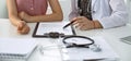 Stethoscope, medical prescription form are lying against the background of a doctor and patient discussing health exam