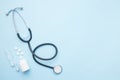 Stethoscope, medication pills and syringe on blue flat lay background. Diagnostics concept. Top view, flat lay, copy space Royalty Free Stock Photo