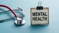 Stethoscope and mental health sign on blue background Royalty Free Stock Photo