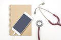 Stethoscope mobile phone and brown notebook on white background, flat lay.