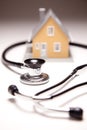 Stethoscope and Model House on Gradated Background Royalty Free Stock Photo