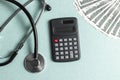 Stethoscope, money and calculator concept. Paid medicine. Health insurance costs Royalty Free Stock Photo