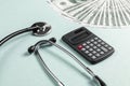 Stethoscope, money and calculator concept. Paid medicine. Health insurance costs Royalty Free Stock Photo