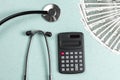 Stethoscope, money and calculator concept. Paid medicine. Health insurance costs Royalty Free Stock Photo