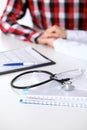 Stethoscope next to hand of doctor reassuring her male patient. Medical ethics and trust concept Royalty Free Stock Photo