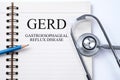 Stethoscope on notebook and pencil with GERD Gastroesophageal R
