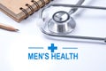 Stethoscope, notebook and pencil with men`s health words. Health Royalty Free Stock Photo