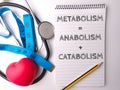 Stethoscope and notebook with the word METABOLISM ANABOLISM CATABOLISM