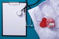 Stethoscope, notepad, heart, vitamins, folded form of a doctor lie on the table Royalty Free Stock Photo