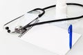 Stethoscope in the office of doctors.Top view of doctor`s desk table, blank paper on clipboard with pen. Copy space Royalty Free Stock Photo