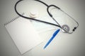 Stethoscope in the office of doctors.Top view of doctor`s desk table, blank paper on clipboard with pen. Copy space Royalty Free Stock Photo