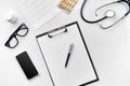 Stethoscope in the office of doctors.Top view of doctor`s desk table, blank paper on clipboard with pen. Copy space Royalty Free Stock Photo