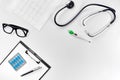 Stethoscope in the office of doctors.Top view of doctor`s desk table, blank paper on clipboard with pen. Copy space Royalty Free Stock Photo