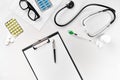 Stethoscope in the office of doctors.Top view of doctor`s desk table, blank paper on clipboard with pen. Copy space Royalty Free Stock Photo