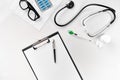 Stethoscope in the office of doctors.Top view of doctor`s desk table, blank paper on clipboard with pen. Copy space Royalty Free Stock Photo