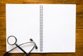 Stethoscope with open blank book on wood background Royalty Free Stock Photo