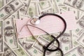 Stethoscope over ecg graph and 100 dollar bills Royalty Free Stock Photo