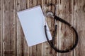 4Stethoscope and paper notebook on wood tablet background copy space medicine concept. and help and consultation