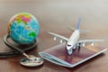 Stethoscope , passport document, airplane and globe. Healthcare and travel insurance concept