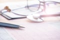 Stethoscope with pen glasses, magnifier and cardiogram and other medicine equipment lay on a table Royalty Free Stock Photo