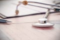 Stethoscope with pen glasses, magnifier and cardiogram and other medicine equipment lay on a table Royalty Free Stock Photo