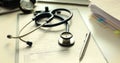 Stethoscope and pen on medical records in doctor premise